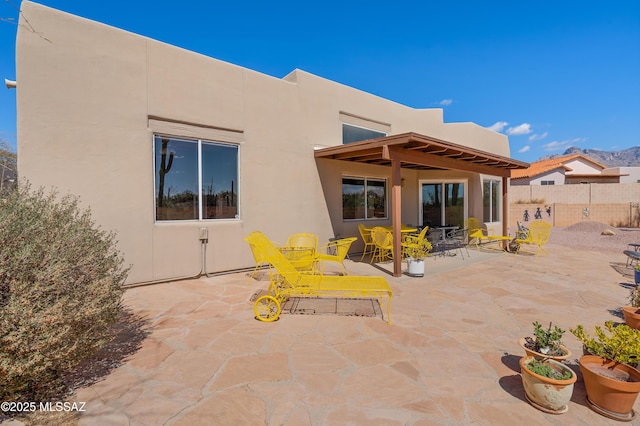 back of property featuring stucco siding, a patio, and fence