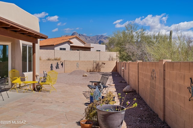 view of patio with a mountain view and a fenced backyard