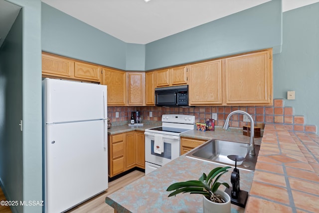 kitchen with backsplash, light brown cabinets, light countertops, white appliances, and a sink