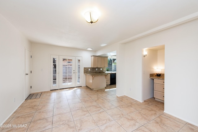 interior space with light stone counters, light tile patterned floors, decorative backsplash, baseboards, and dishwasher