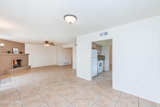 unfurnished living room featuring light tile patterned flooring, visible vents, a fireplace, and ceiling fan