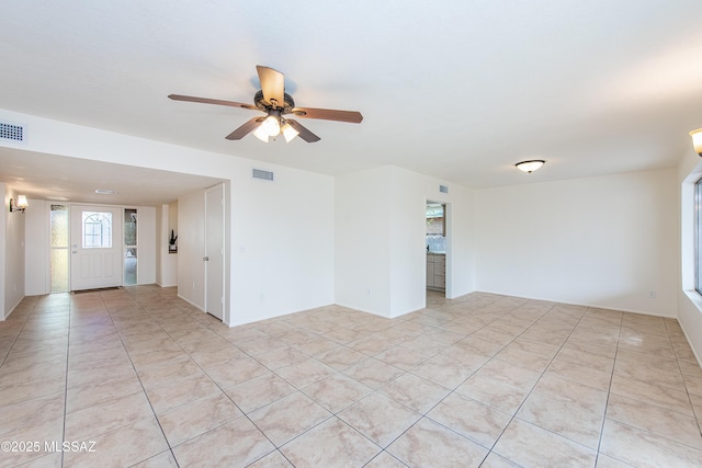 empty room featuring visible vents, ceiling fan, and light tile patterned flooring