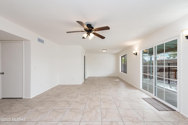 spare room featuring light tile patterned floors, visible vents, and ceiling fan