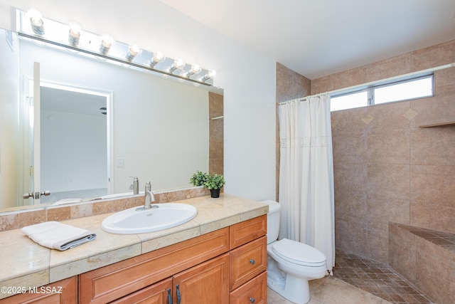 full bath featuring a tile shower, tile patterned floors, toilet, and vanity