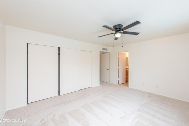 unfurnished bedroom featuring light carpet, visible vents, connected bathroom, and a closet