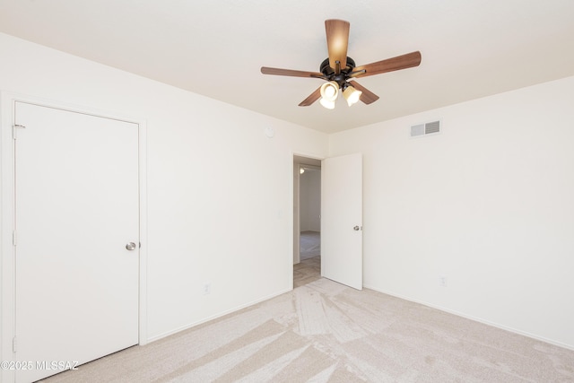 unfurnished bedroom with ceiling fan, baseboards, visible vents, and light carpet