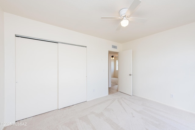 unfurnished bedroom with a closet, visible vents, ceiling fan, and carpet