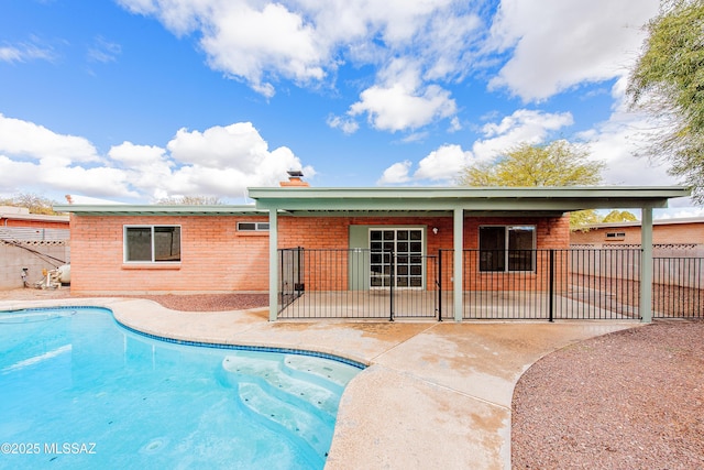 back of property featuring a patio, fence, a fenced in pool, and a chimney