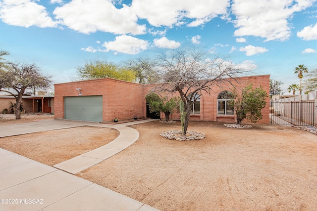 view of front of property featuring brick siding, an attached garage, driveway, and fence