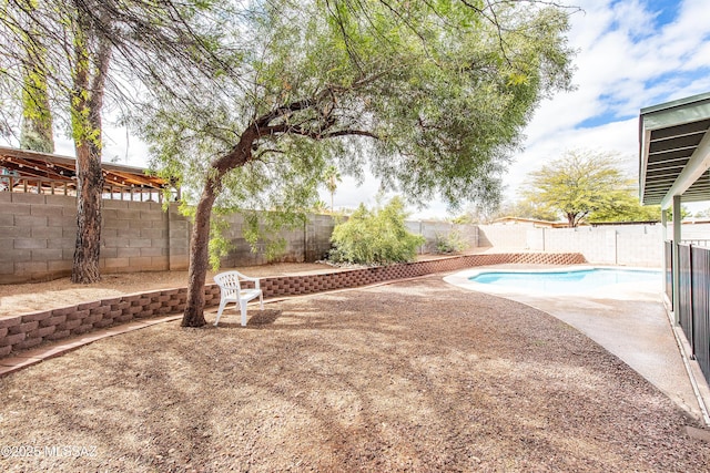 view of yard featuring a fenced in pool, a fenced backyard, and a patio area