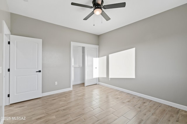 unfurnished bedroom with ceiling fan, a closet, baseboards, and light wood-style flooring