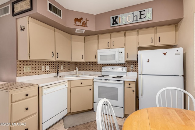 kitchen with white appliances, visible vents, a sink, and cream cabinetry