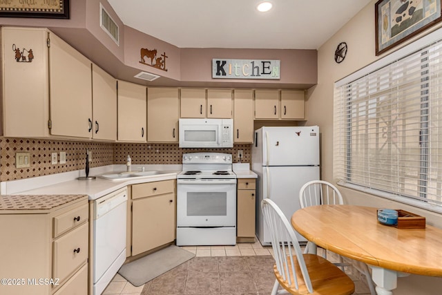 kitchen featuring white appliances, tasteful backsplash, visible vents, light countertops, and a sink