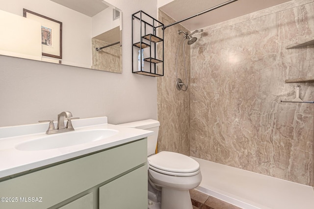 bathroom with a stall shower, visible vents, vanity, and toilet