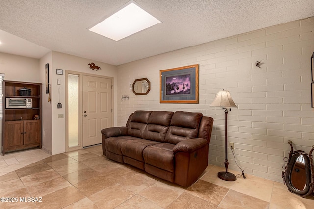 living room with a textured ceiling and a skylight