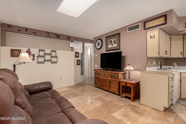 living room featuring a textured ceiling and visible vents