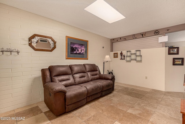 living area with a textured ceiling and brick wall