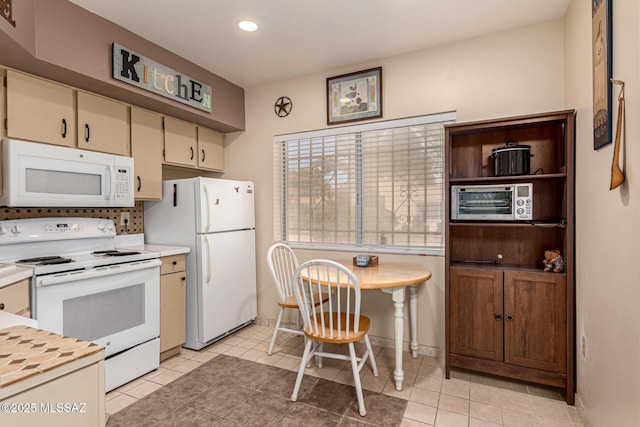 kitchen with recessed lighting, light countertops, light tile patterned flooring, white appliances, and baseboards