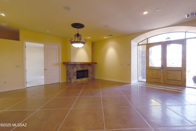 tiled foyer featuring recessed lighting, visible vents, baseboards, french doors, and a tiled fireplace