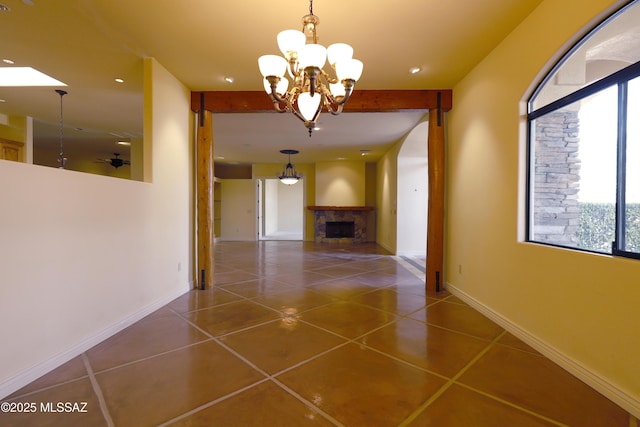 hall featuring a chandelier, tile patterned flooring, and baseboards