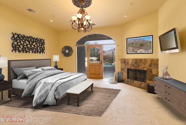 carpeted bedroom featuring a stone fireplace, recessed lighting, visible vents, access to outside, and an inviting chandelier