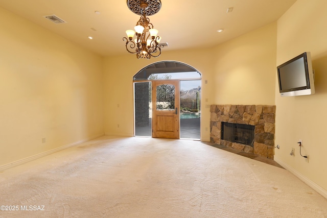 unfurnished living room with carpet floors, an inviting chandelier, baseboards, and visible vents