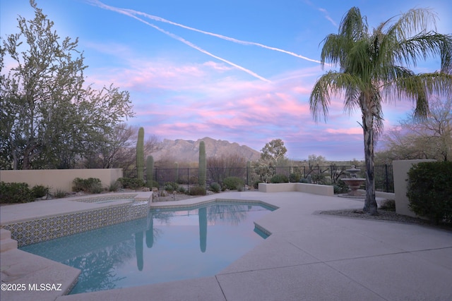 view of swimming pool with a fenced in pool, a patio, a jacuzzi, fence, and a mountain view