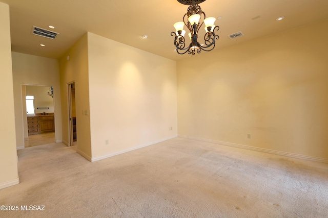 unfurnished room with a chandelier, light colored carpet, visible vents, and baseboards