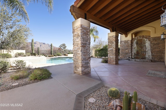 view of patio / terrace featuring a fenced backyard, a mountain view, and a fenced in pool