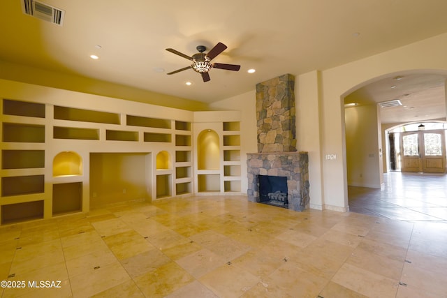 unfurnished living room featuring ceiling fan, built in shelves, a fireplace, visible vents, and baseboards