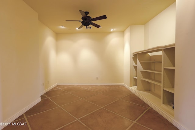 unfurnished room featuring a ceiling fan, tile patterned flooring, built in shelves, and baseboards