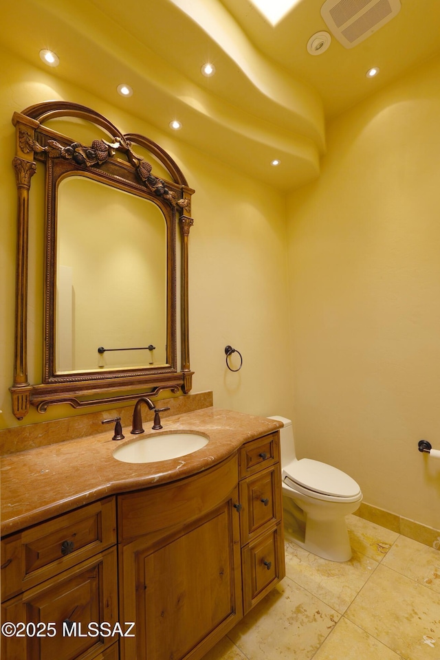 bathroom with toilet, vanity, visible vents, and recessed lighting