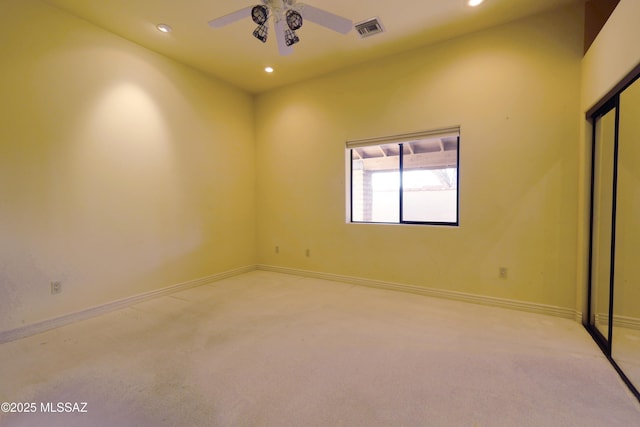 spare room featuring light carpet, recessed lighting, visible vents, and baseboards