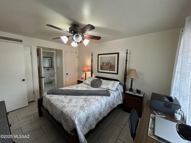 bedroom with ceiling fan, a sink, visible vents, and ensuite bathroom