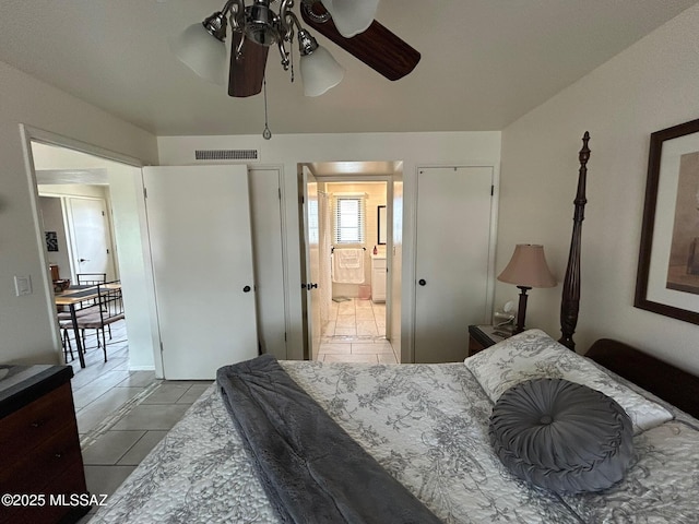 bedroom featuring ensuite bath, visible vents, and tile patterned floors