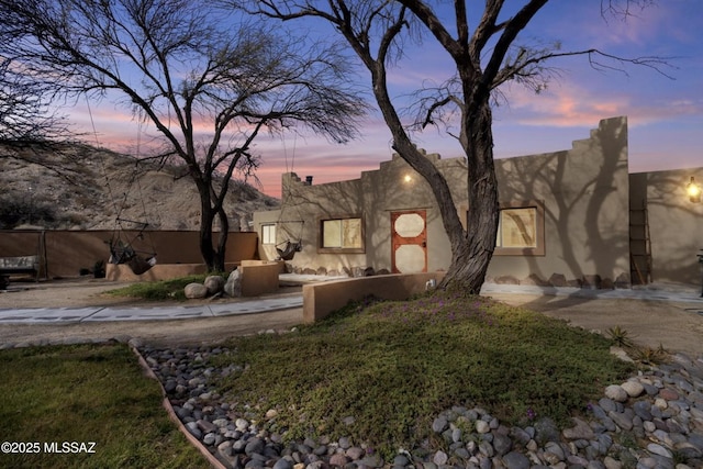 pueblo-style house featuring fence