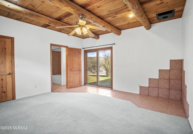 unfurnished bedroom featuring wood ceiling, carpet flooring, ensuite bath, access to outside, and beamed ceiling