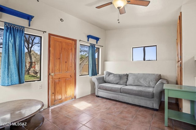 living area featuring a ceiling fan and tile patterned floors