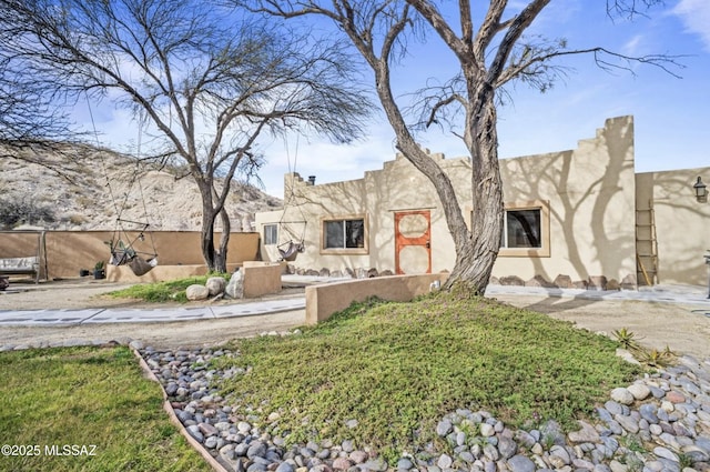 pueblo-style house with fence