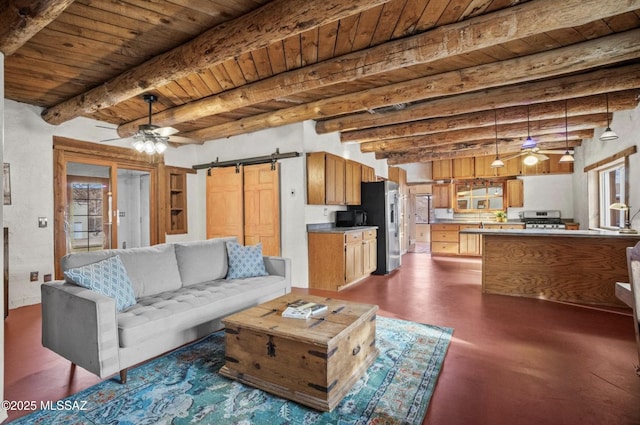 living room with a barn door, beamed ceiling, wood ceiling, and a ceiling fan