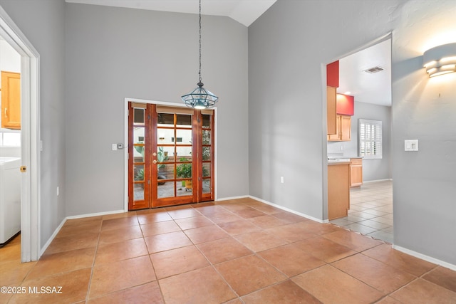 unfurnished dining area featuring high vaulted ceiling, baseboards, visible vents, and light tile patterned flooring