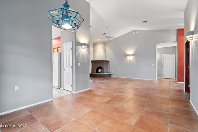 unfurnished living room featuring light tile patterned floors, lofted ceiling, a large fireplace, ceiling fan with notable chandelier, and visible vents