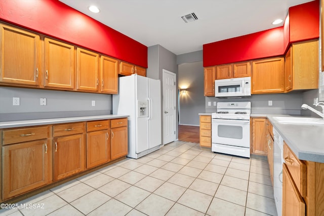 kitchen featuring white appliances, light tile patterned floors, visible vents, light countertops, and a sink