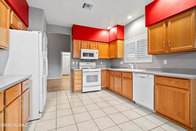 kitchen featuring light countertops, white appliances, a sink, and visible vents