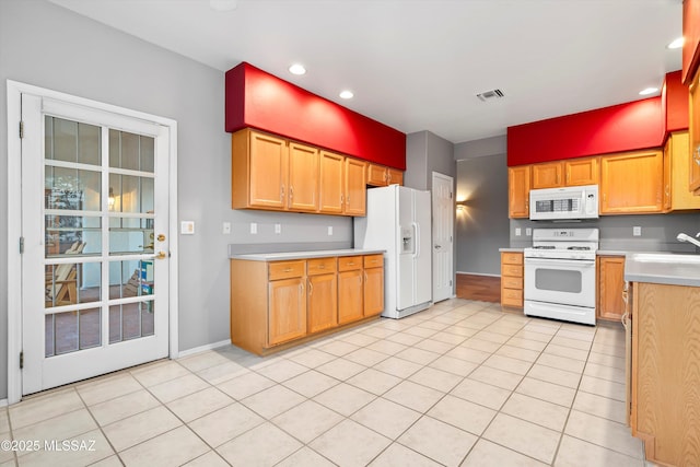 kitchen with light tile patterned floors, white appliances, visible vents, baseboards, and light countertops