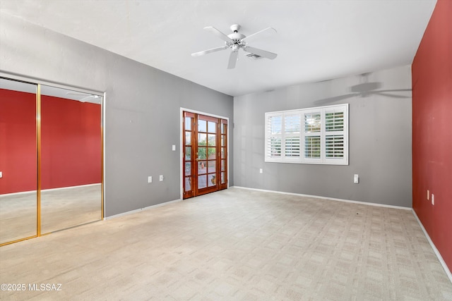 empty room featuring ceiling fan, carpet flooring, and french doors