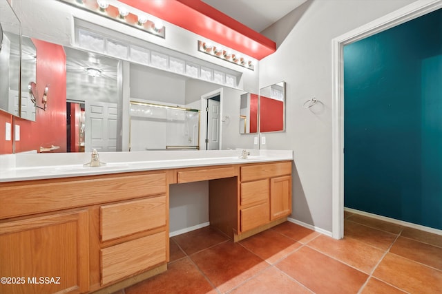 full bathroom featuring double vanity, tile patterned flooring, a shower stall, and baseboards