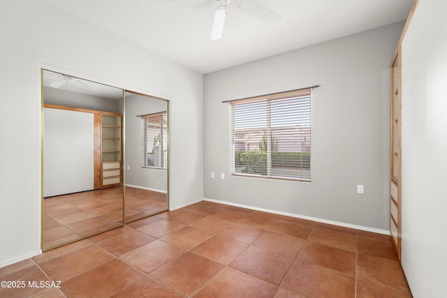 unfurnished bedroom featuring a closet, ceiling fan, baseboards, and light tile patterned floors