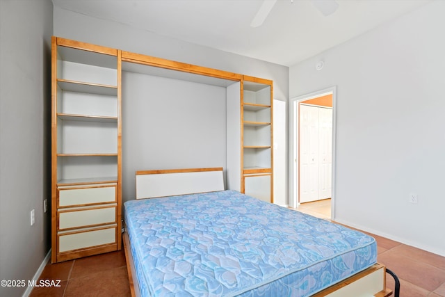 tiled bedroom featuring a ceiling fan and baseboards