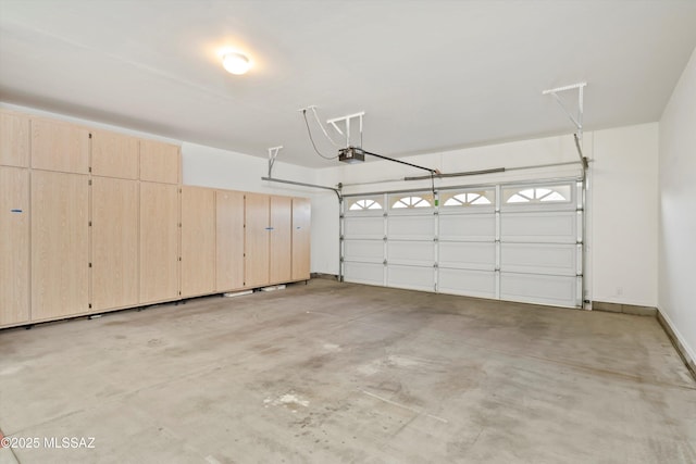 garage with baseboards and a garage door opener